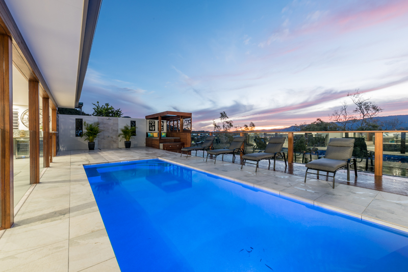 Home Design External. From under Alfresco looking out to pool and view. Dusk.