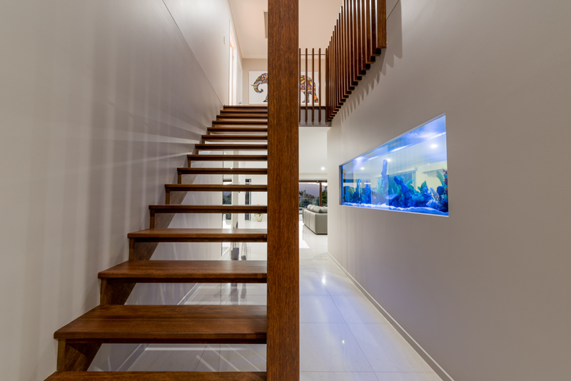 Home Design Feature timber to the staircase and wall mounted fish tank.