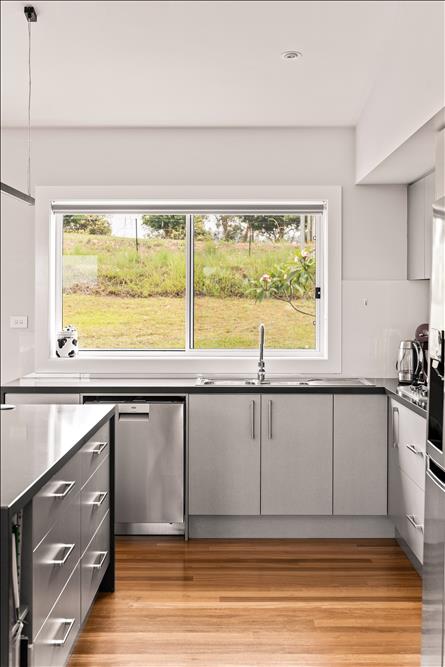 2 pac finish kitchen with AEG dishwasher and view of the farmland through the window