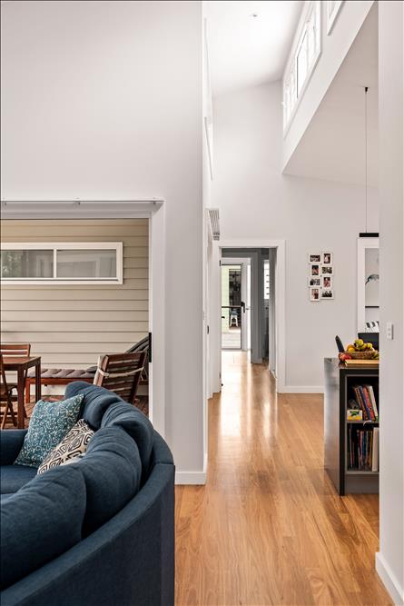 Hall lightwell showing the raking ceiling over the kitchen meeting the high-light windows over the sliding door